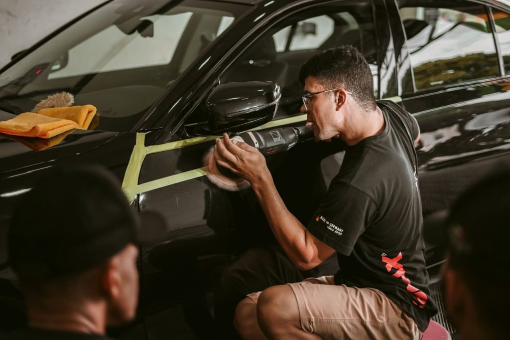 Detailer polishing car paint by hand